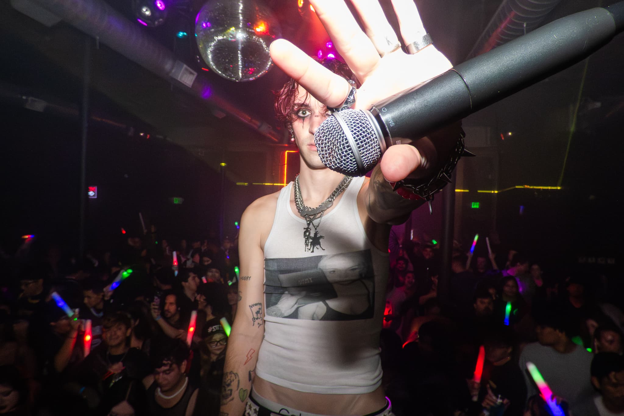 Candid live music concert photography by Chase Tipton - Macro detail of guitarist hand, with the crowd in the background